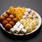 Indian sweets in a plate includes Gulab Jamun, Rasgulla, kaju katli, morichoor / Bundi Laddu, Gujiya or Karanji for diwali celebration